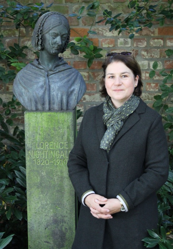 Dr. Annett Büttner neben der Büste von Florence Nightingale in Kaiserswerth